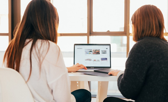 women working together on a laptop